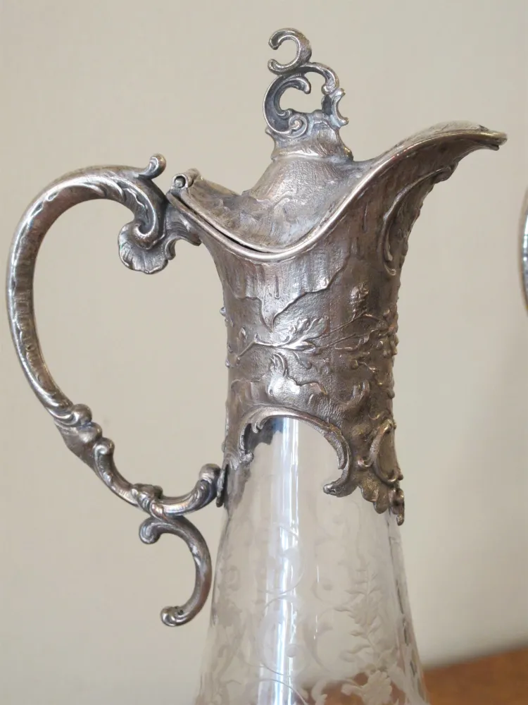 deux pichets antiques WMF avec un design complexe et des poignées décoratives, dans un cadre élégant