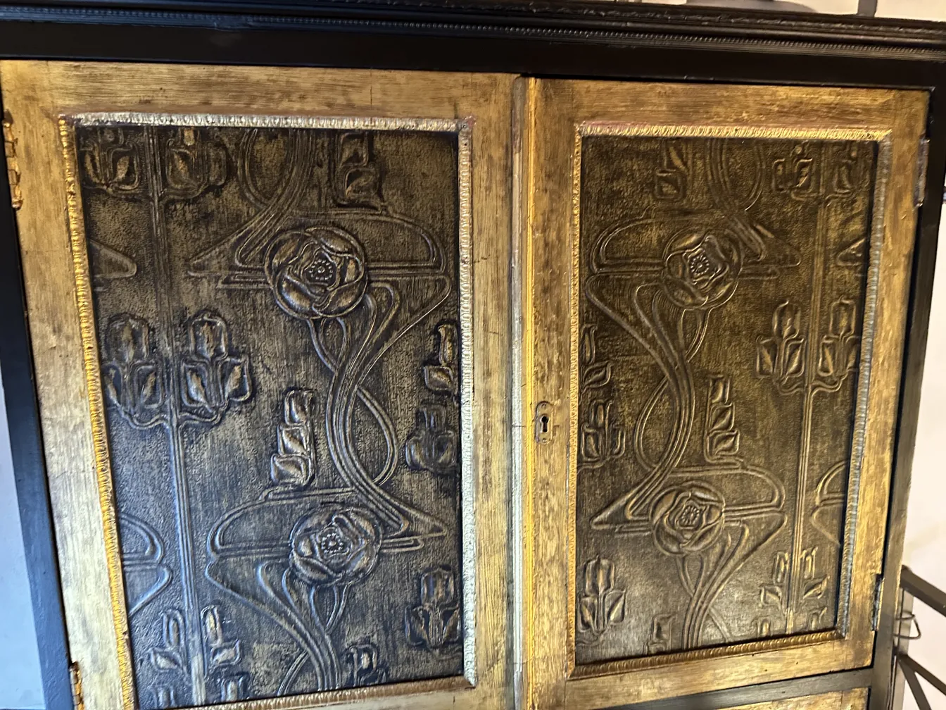 Antique bar cabinet with floral engravings in gold