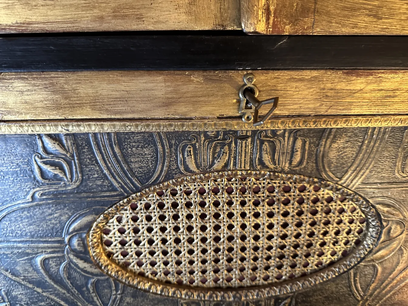 Mueble bar antiguo con detalles elaborados y una cerradura distintiva.