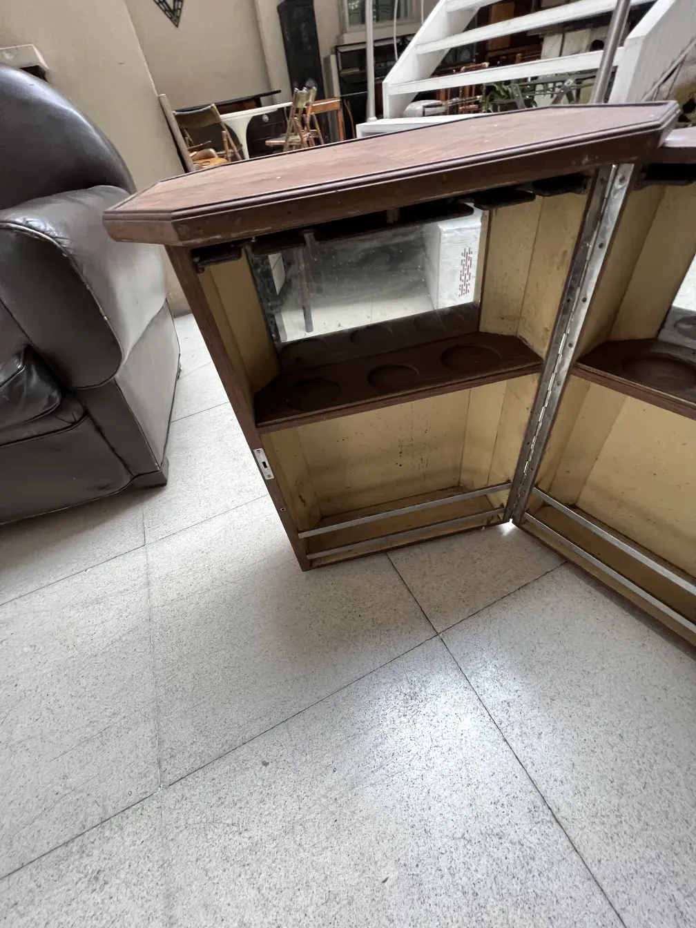 Bar antigo com espelho e espaço de armazenamento, ambiente acolhedor.