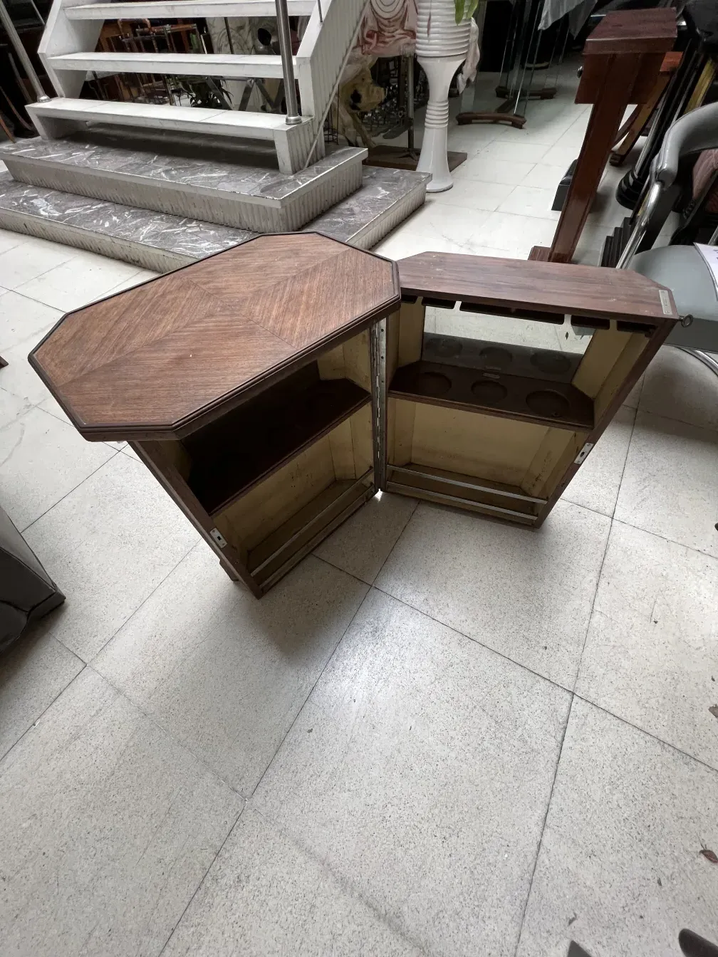 Mueble bar antiguo esquinero de madera con espacio para botellas.