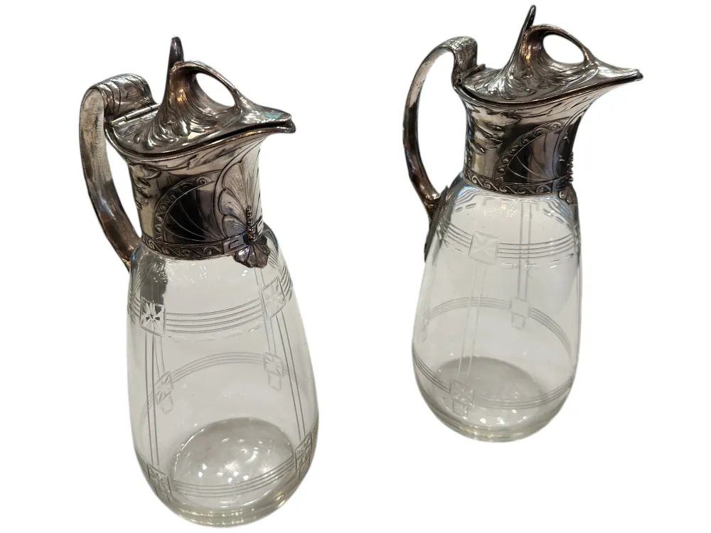 Zwei antike WMF Krüge mit dekorativen Details und einem eleganten Design in einer klassischen Umgebung.