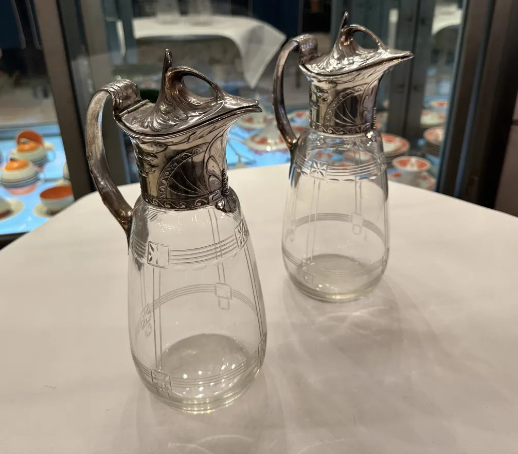 Duas jarras antigas WMF com detalhes decorativos e um design elegante em um ambiente clássico.