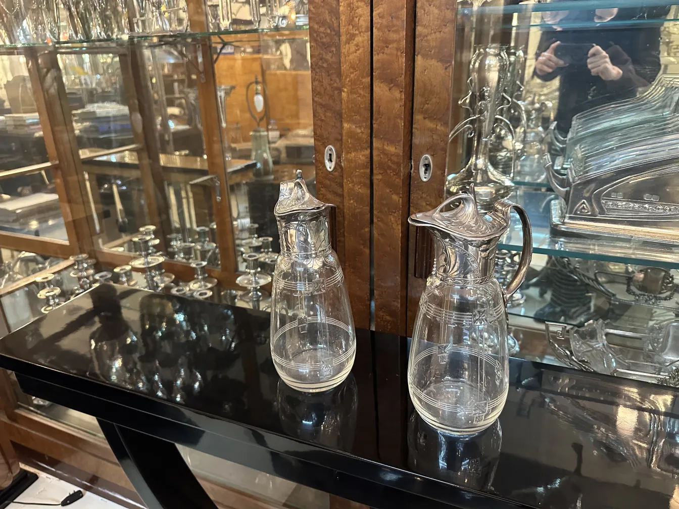 Deux pichets anciens WMF avec des détails décoratifs et un design élégant dans un cadre classique.