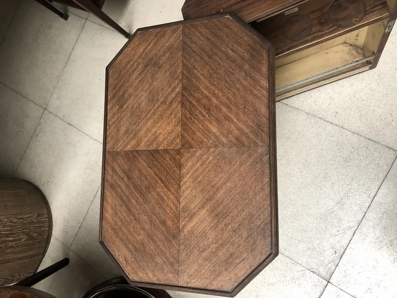 Antique bar with a wooden surface featuring diamond patterns, surrounded by other furniture.