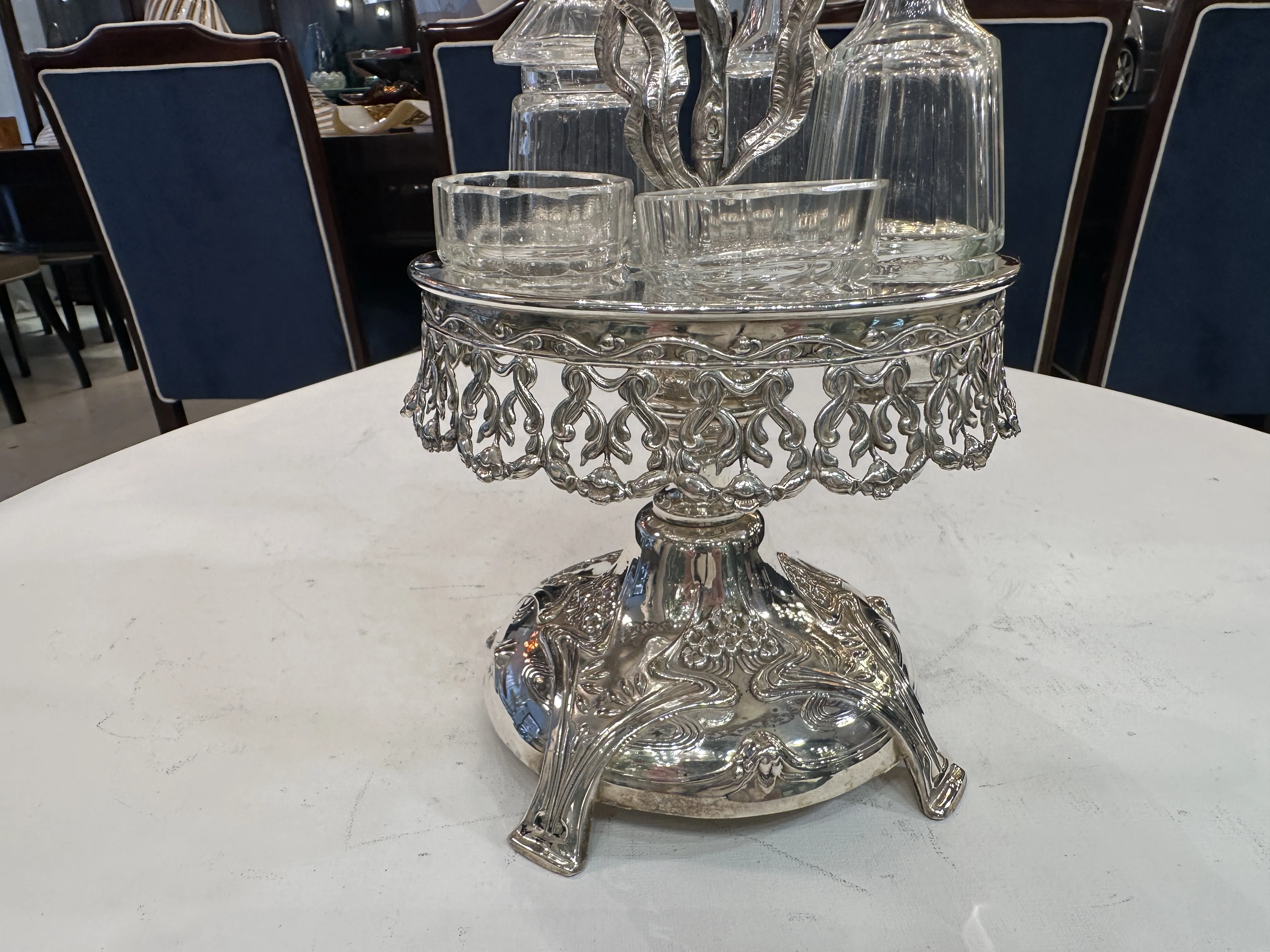 Ensemble ancien de salière et poivrière avec huile et vinaigre sur une base décorative.