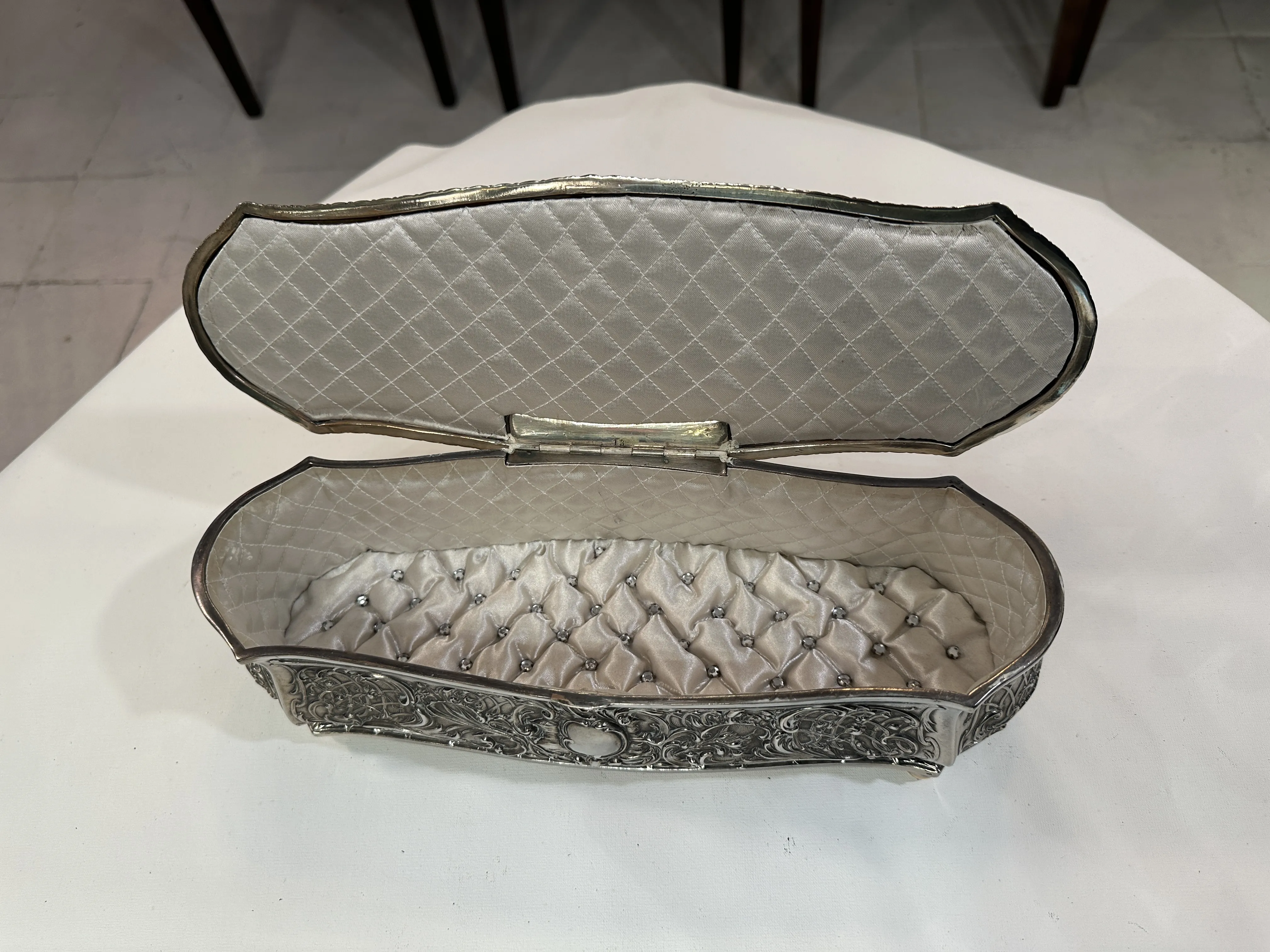 open antique box with decorative lid and padded interior