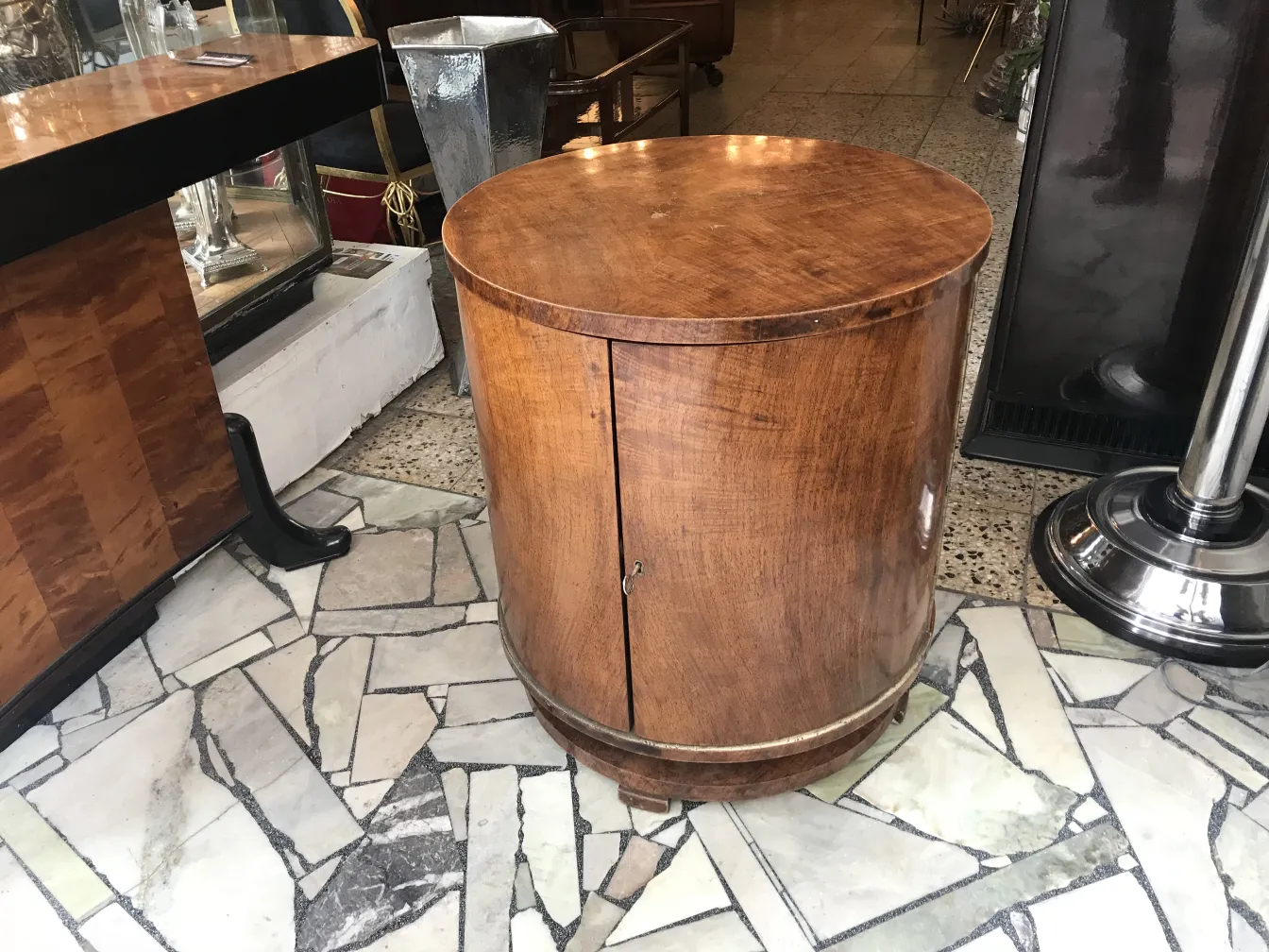 Antique wooden bar cabinet in cylindrical shape, decorated, in a classic setting.