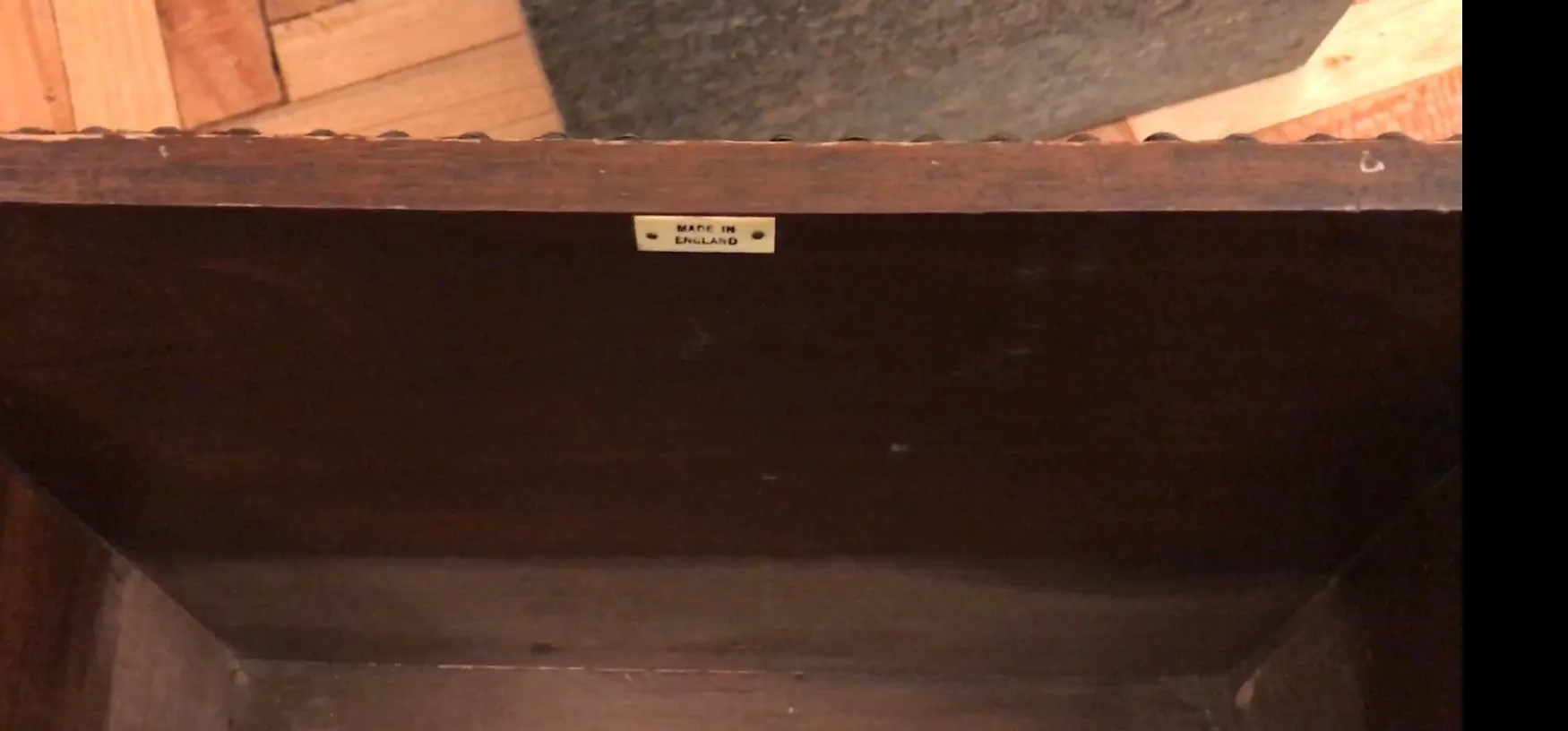 Mobile bar antico con etichetta 'Made in England', interno scuro.