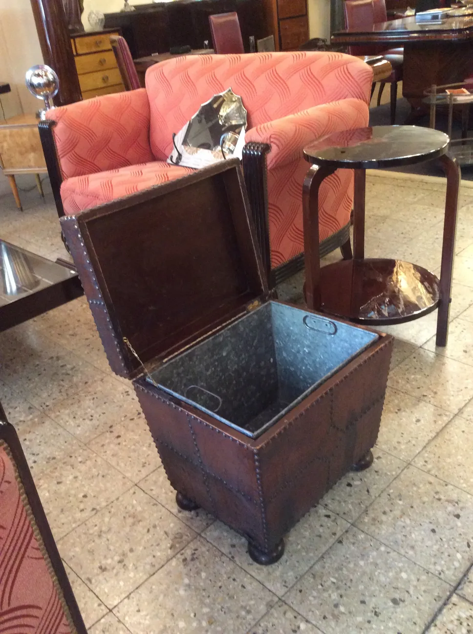 Antiker Bar-Container mit metallic innen und roter Polsterung im Wohnzimmer.