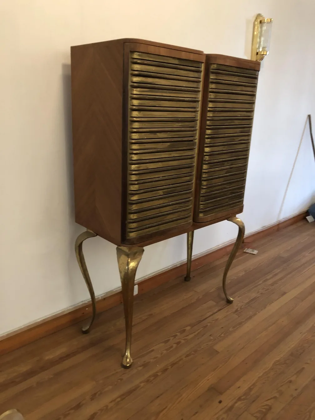 Bar antigo com detalhes dourados e pernas elegantes em um ambiente acolhedor.