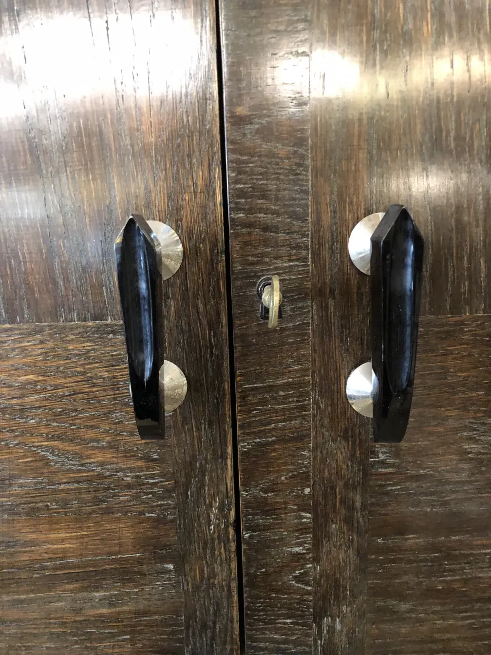 Antiker Cocktailschrank mit dunklen Griffen und feinen Details.