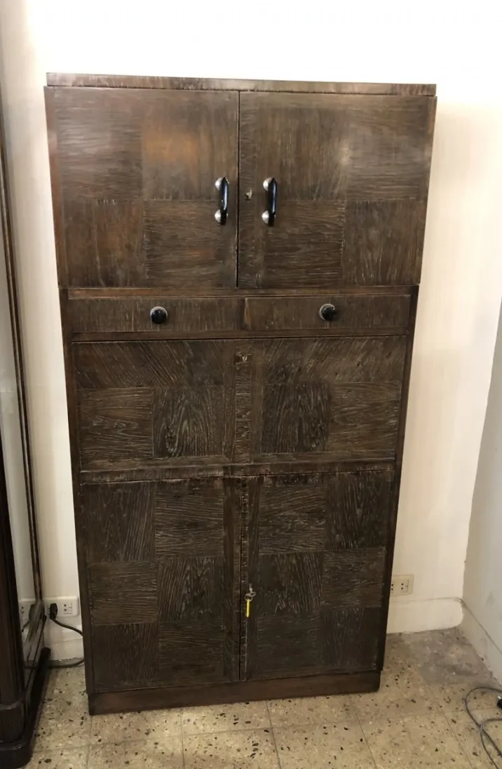 Mueble bar antiguo de dos puertas y cajones, con acabado en tonos marrones