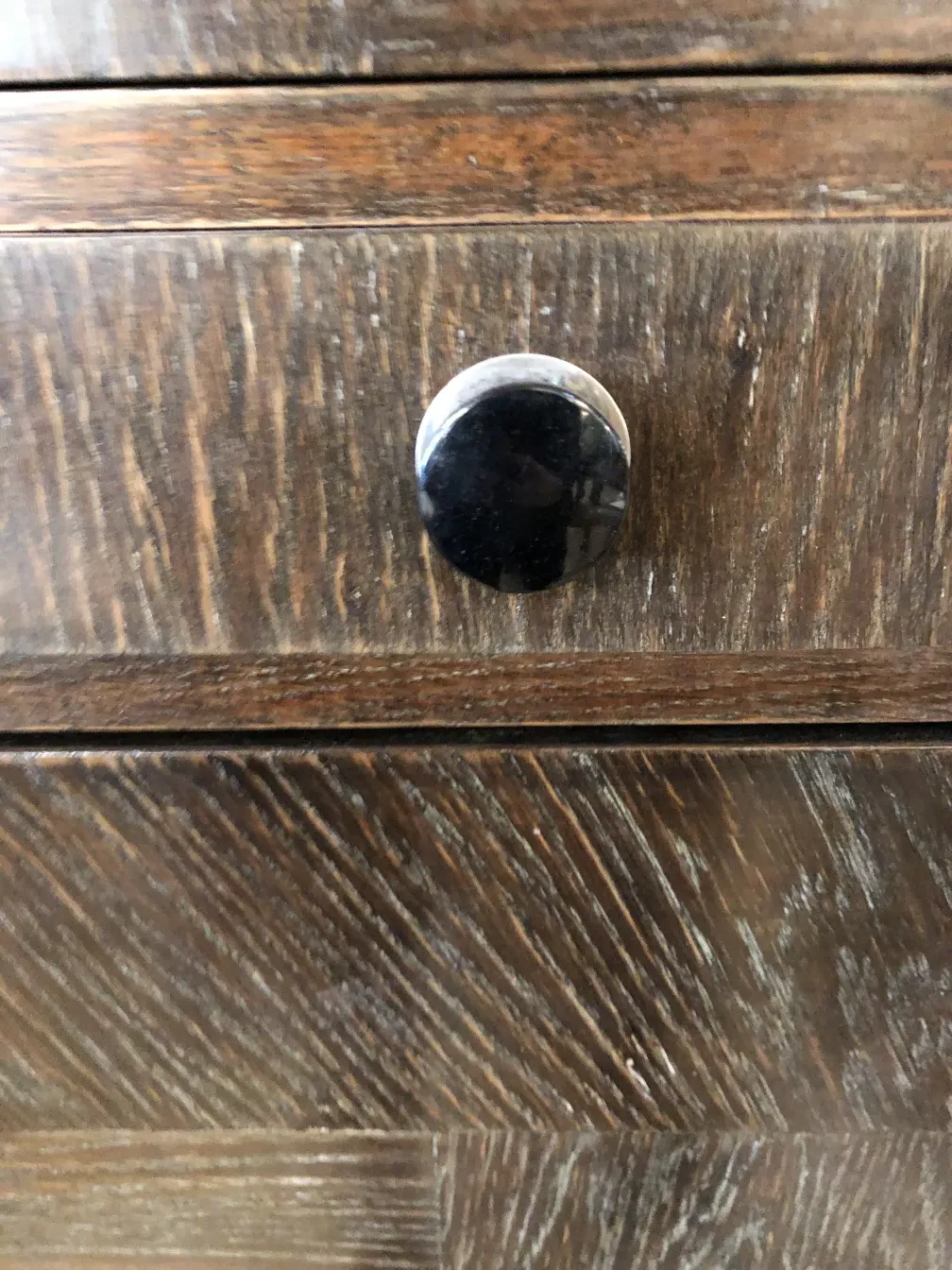 detalle de un mueble bar antiguo con un tirador redondo negro