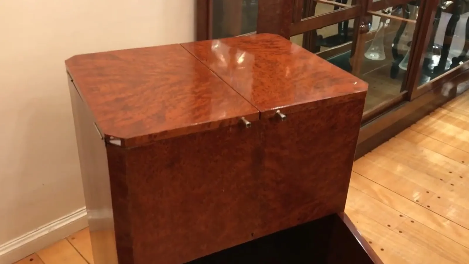 Mueble bar antiguo de madera con acabado brillante, rodeado de ambiente acogedor.