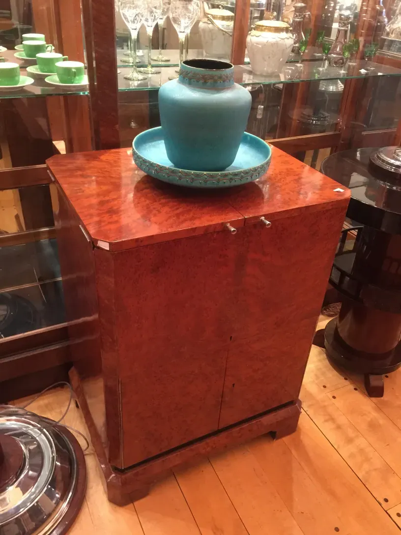 Meuble à cocktail ancien avec surface brillante et décoration bleue.