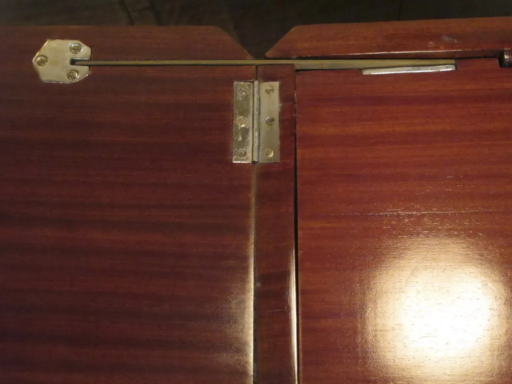 Detail of an antique bar cabinet with metal fittings.
