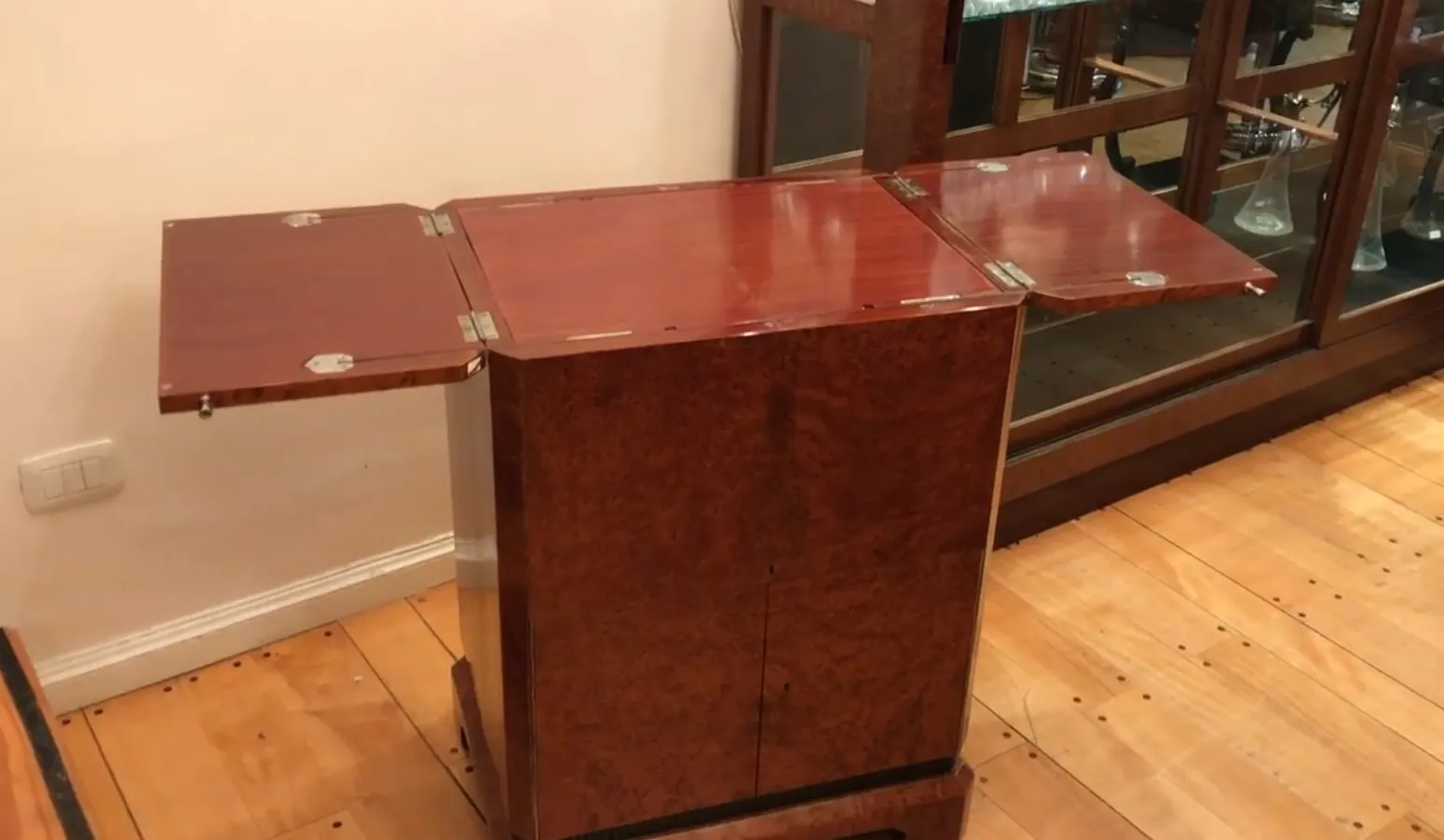 Mueble bar antiguo de madera con espacio para botellas.