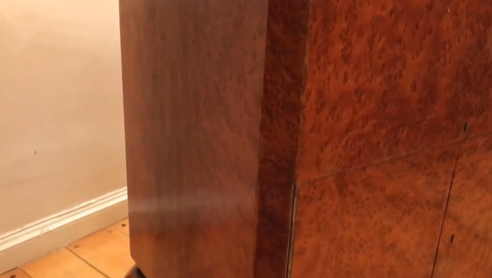 Bar aparador antigo de madeira com acabamento brilhante e detalhes elegantes em um ambiente aconchegante.