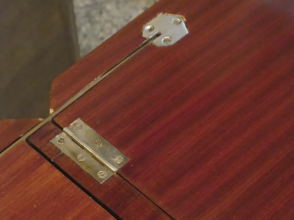 Detalle de un mueble bar antiguo con bisagras de metal.