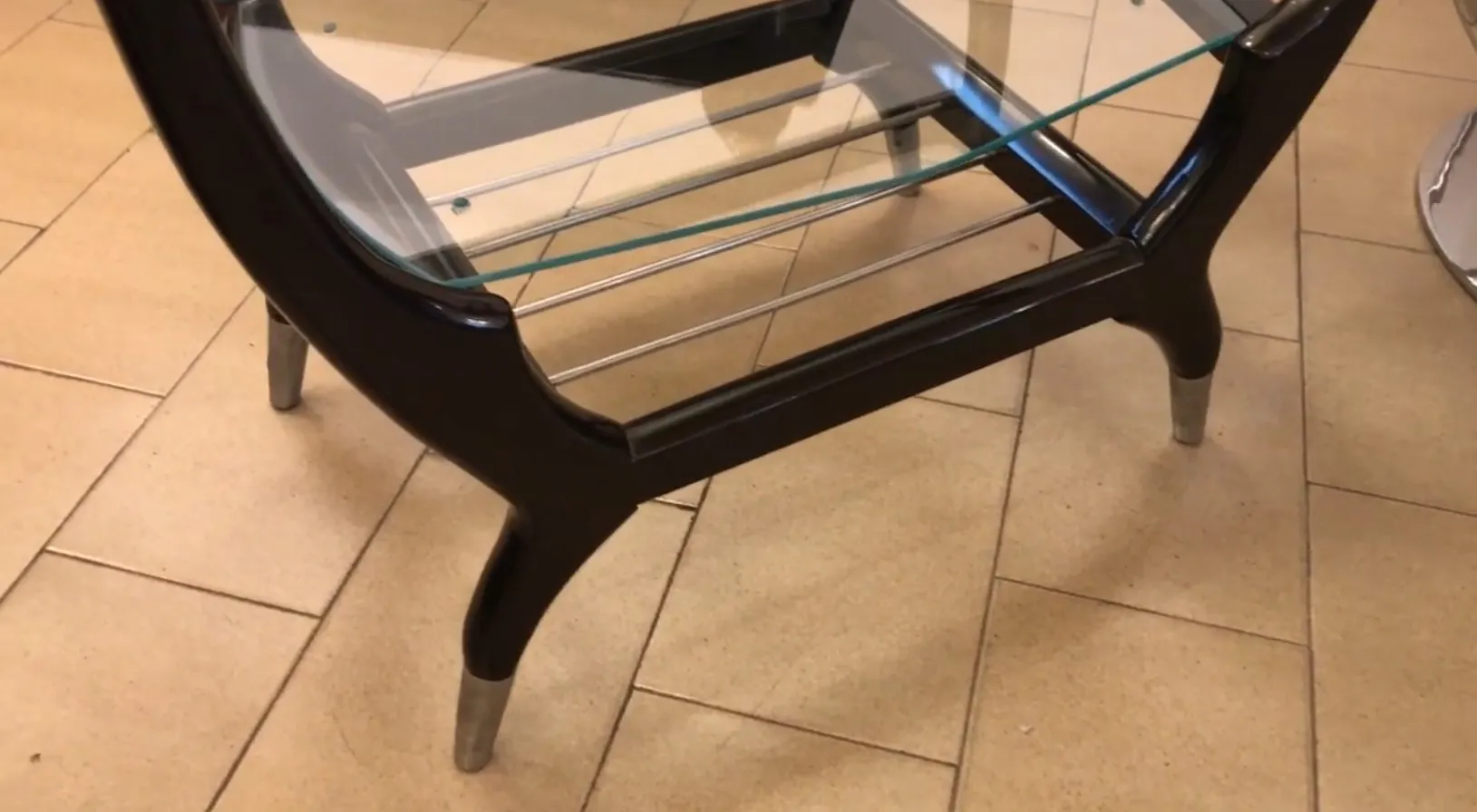 Mueble bar antiguo con cristal y patas elegantes en un ambiente cálido.