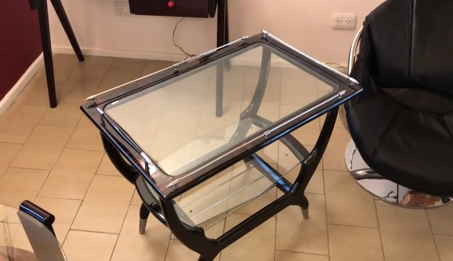 Mobile bar antico con piano in vetro in un contesto moderno.