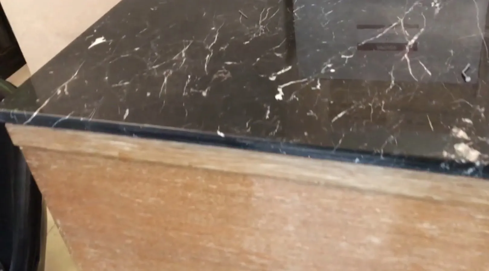 Mueble bar antiguo de madera con superficie de mármol, ambiente acogedor.