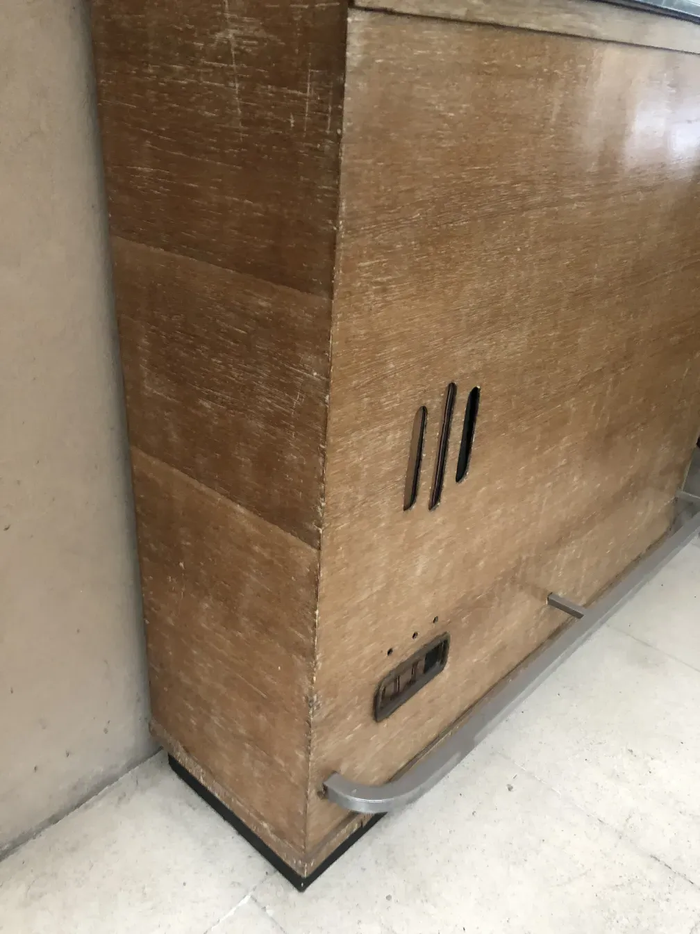 Mobile bar antico con finitura in legno chiaro e ripiani sopra.