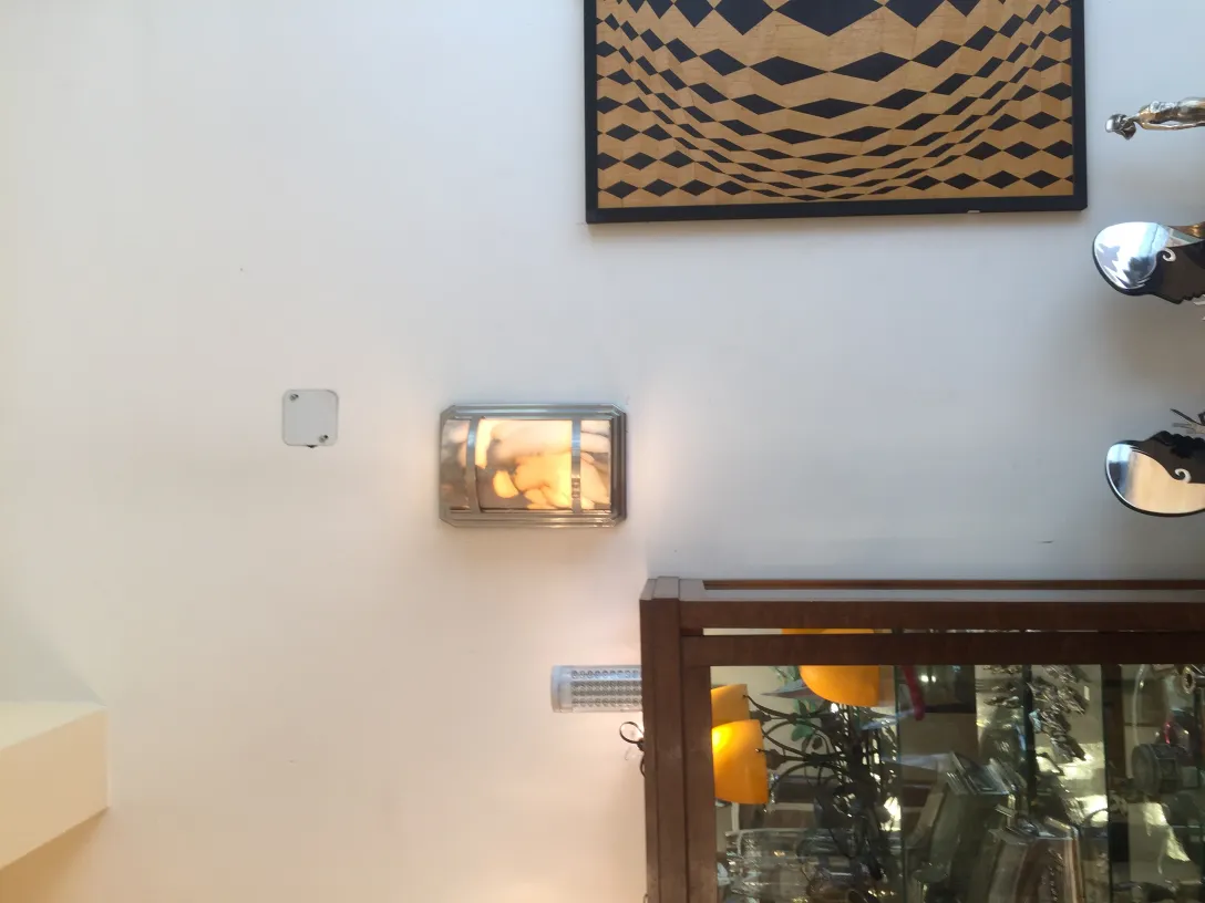 Pair of antique sconces shining on the wall, elegant decor.