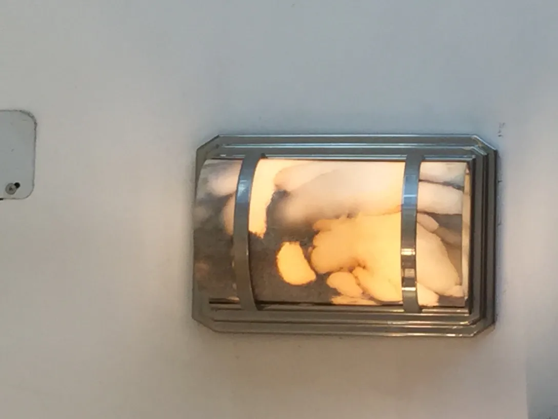 壁に温かい光を放つ古いウォールランプのペア。