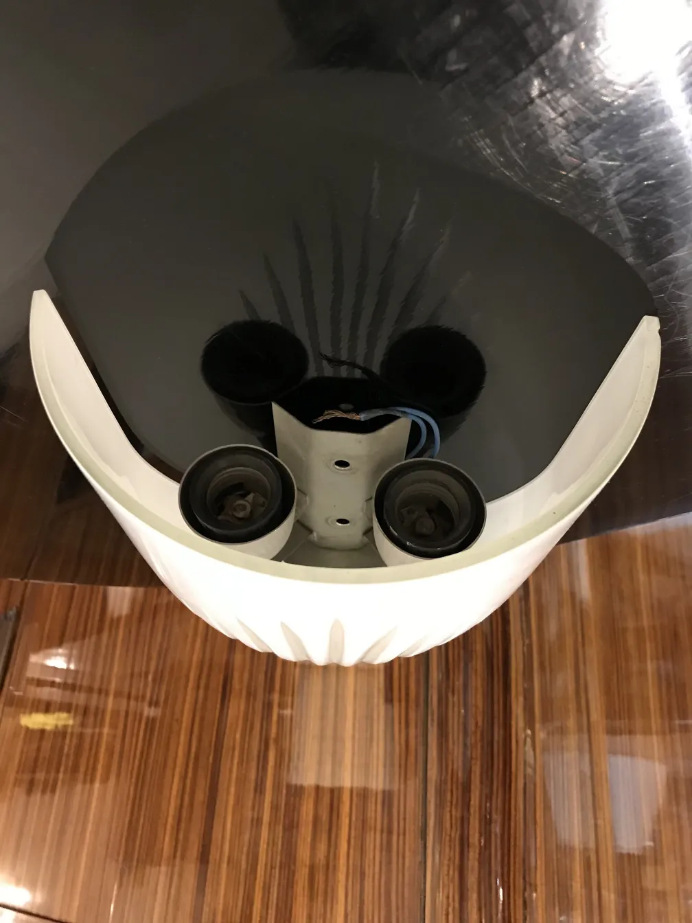 Par de luminárias de parede antigas com forma oval, cor branca e componentes elétricos visíveis