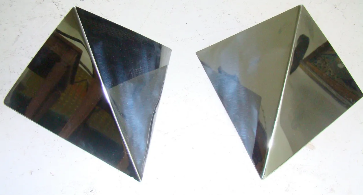 Antique sconces with geometric design, two shiny units.