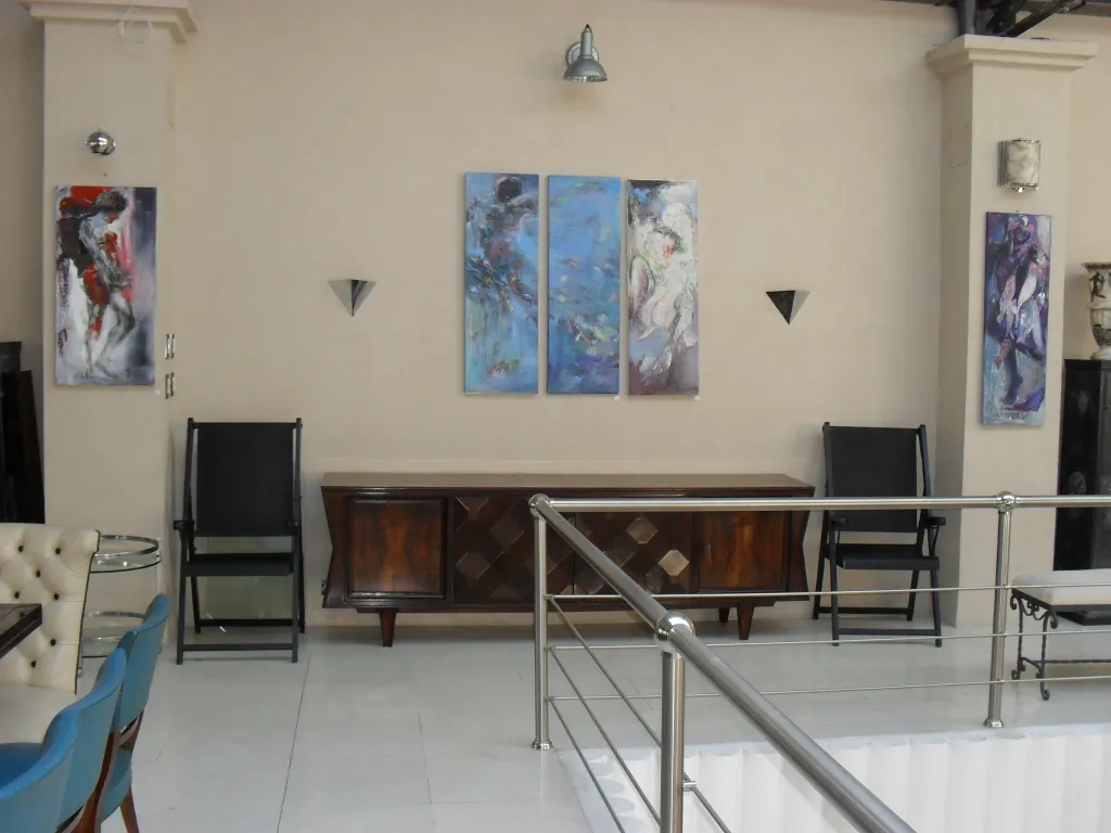 Dois apliques antigos em uma parede clara com pinturas