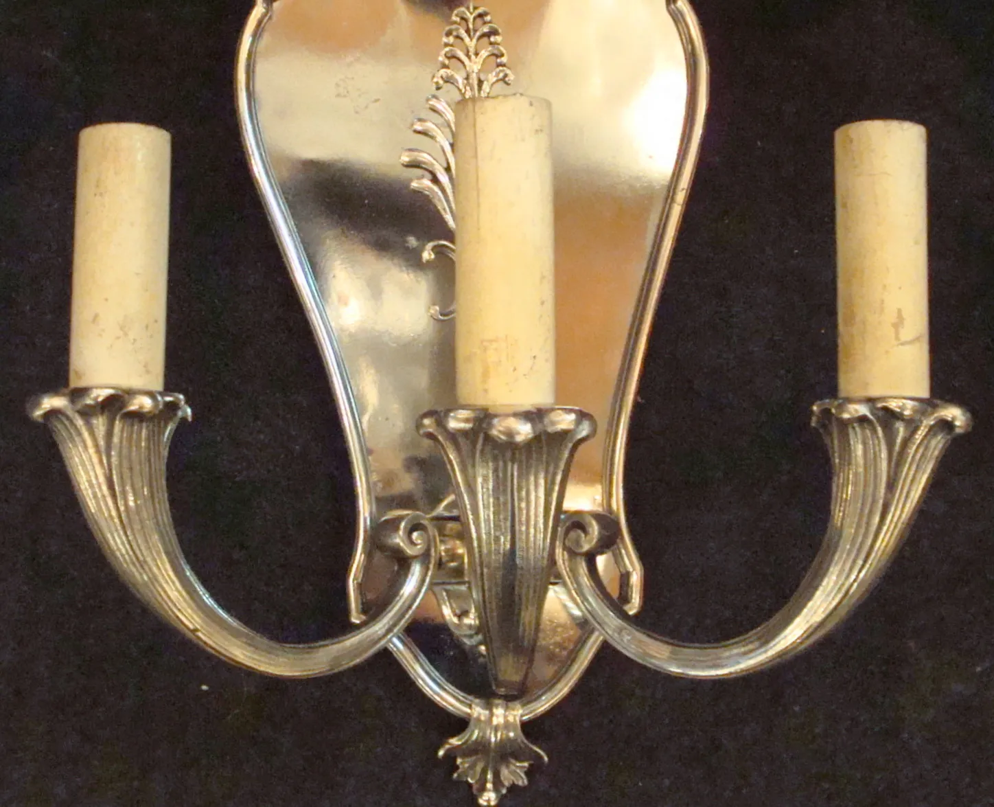 Antique pair of sconces with decorative arms made of metal.