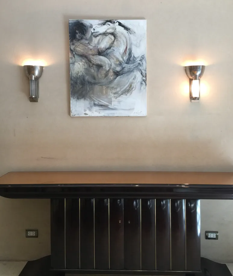 Par de luminárias de parede antigas emitindo luz suave ao lado de uma pintura