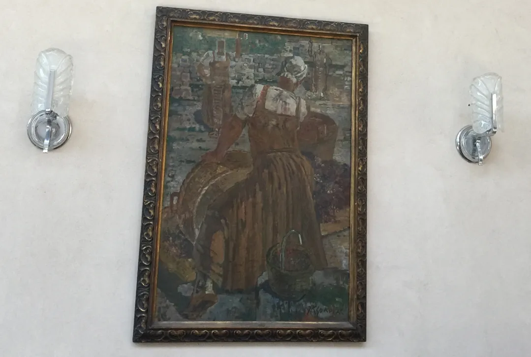 Pair of antique sconces on the wall beside a painting