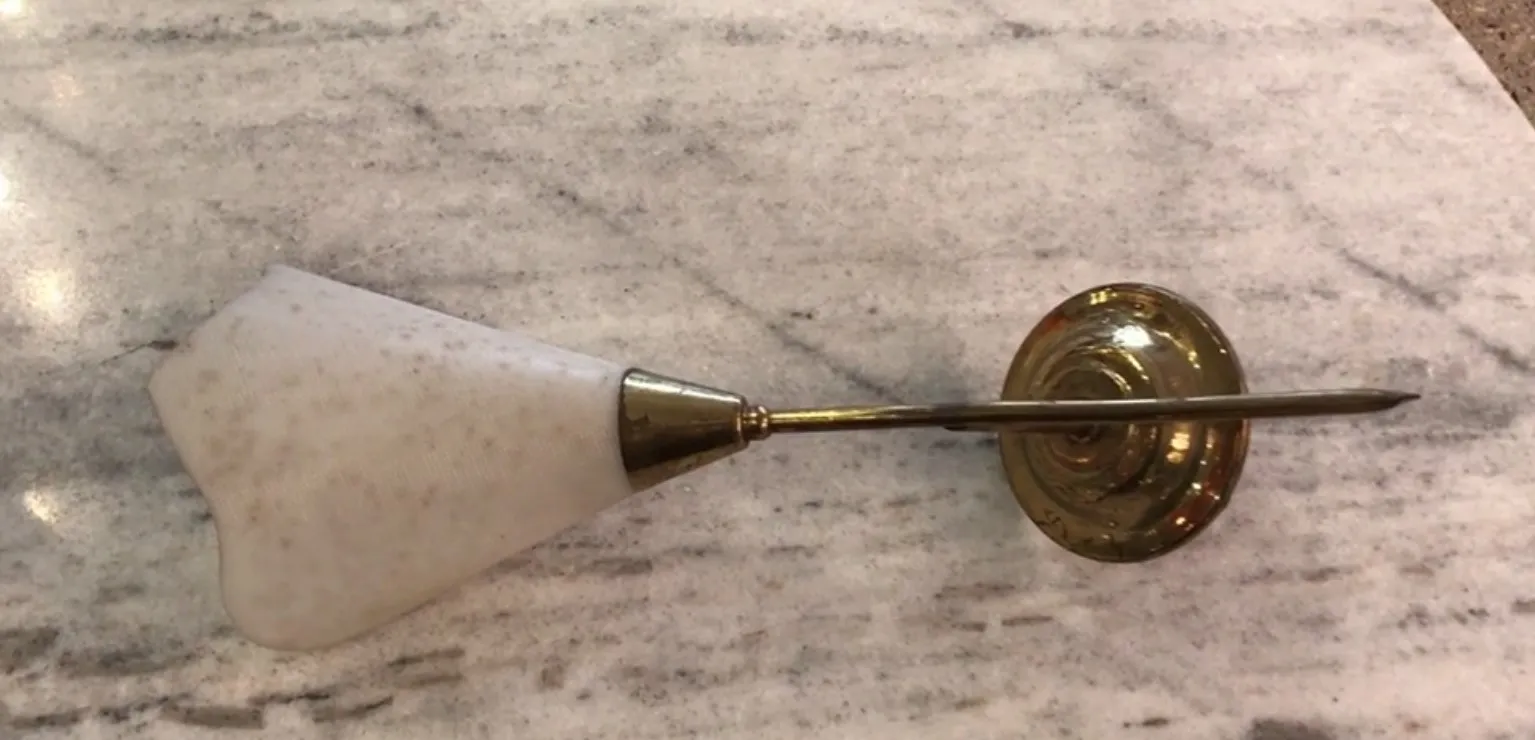 Paire d'appliques anciennes avec base dorée et abat-jour en marbre, sur un fond en marbre clair.