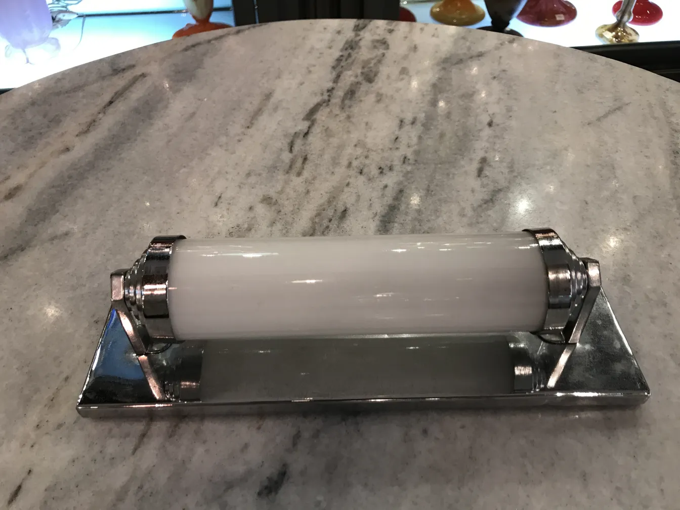 Apliques antiguos de metal y vidrio, elegante diseño, en superficie de mármol.