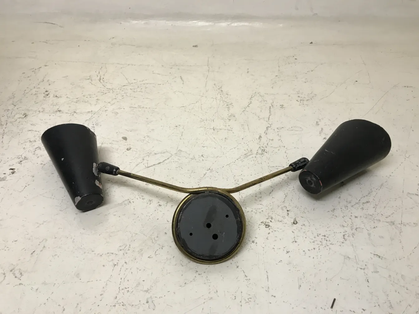 Antique pair of sconces featuring metal arms and a round base, classic style.