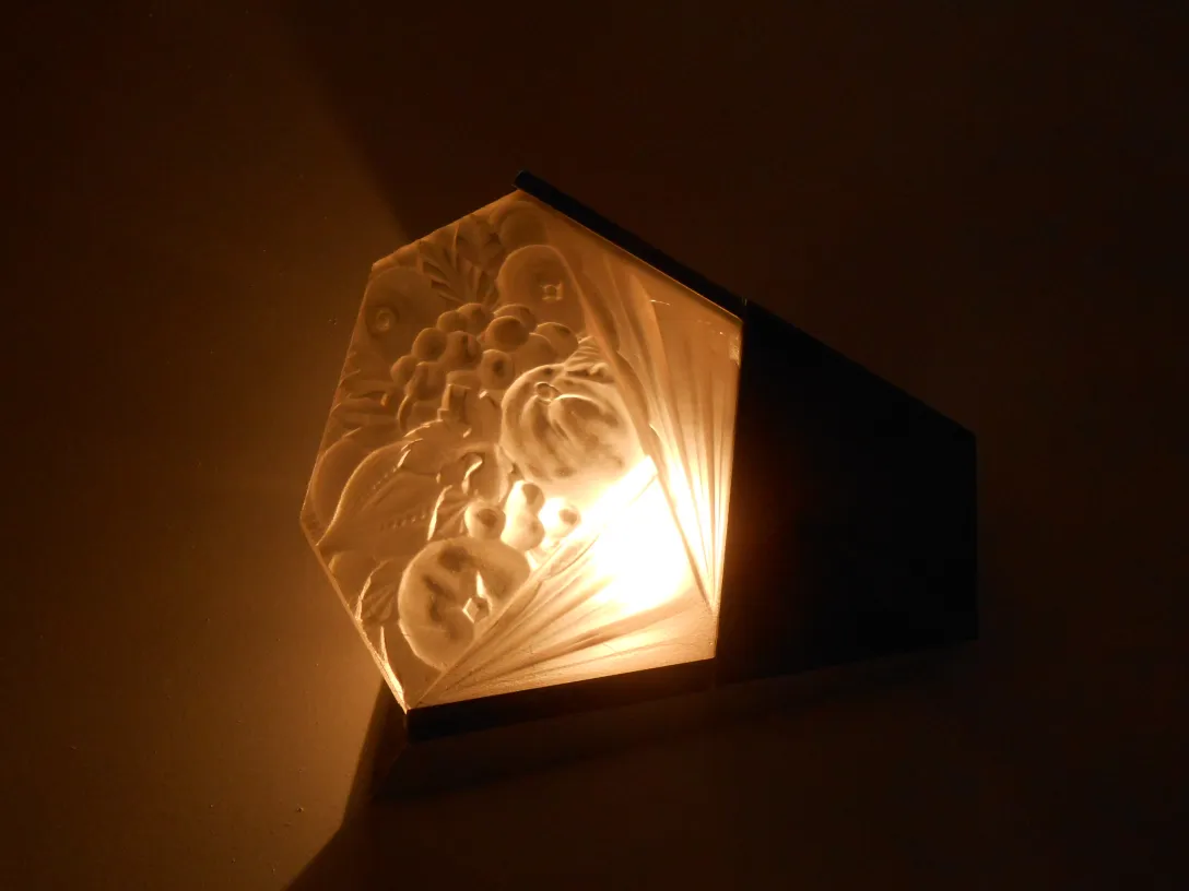 Pair of antique sconces featuring decorative reliefs and warm light