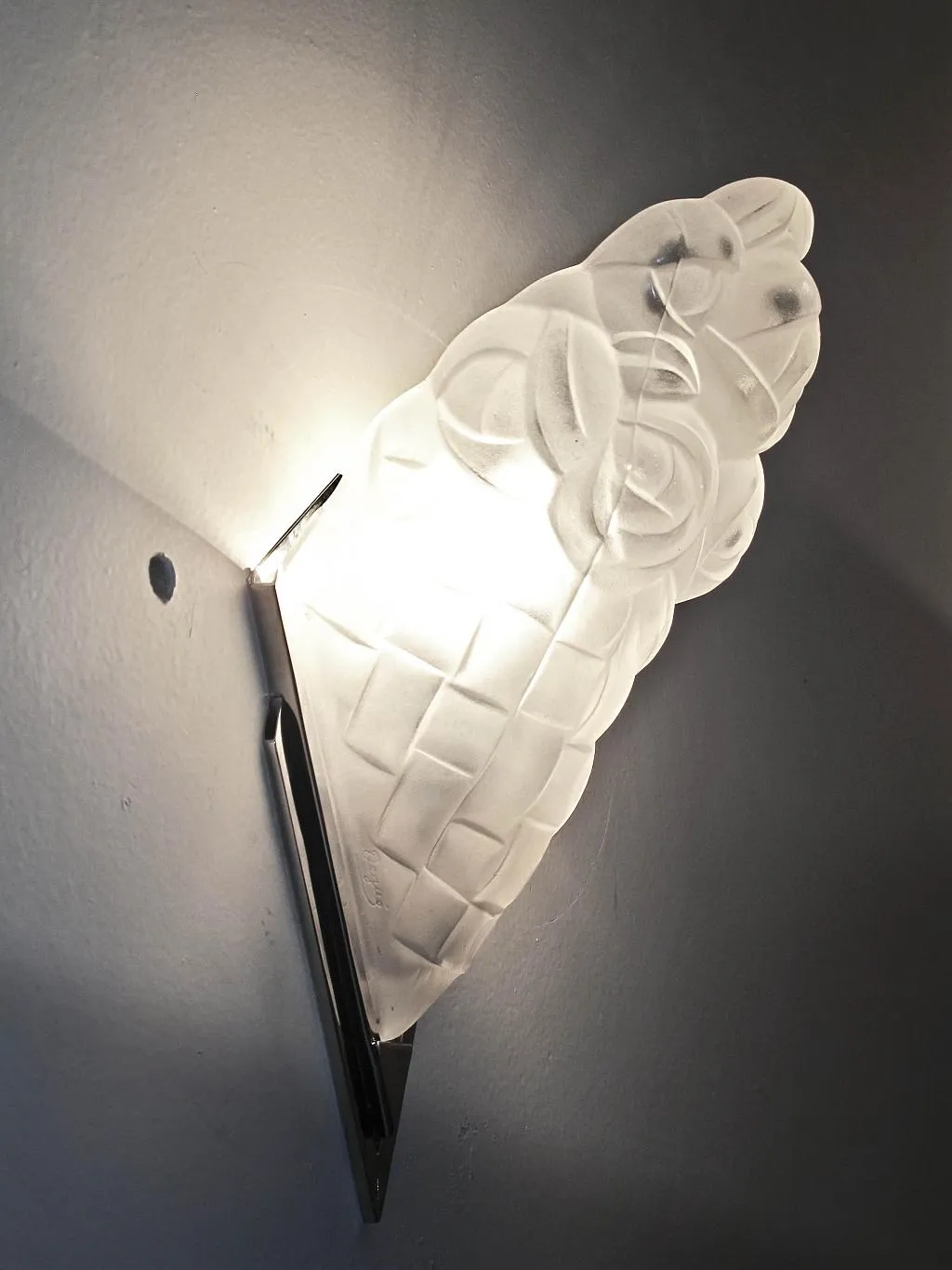 Par de apliques antiguos con diseño detallado, iluminando la pared. Ambiente cálido y acogedor.