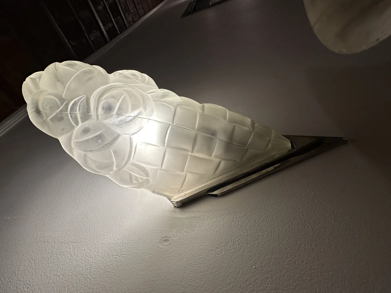 Pair of antique sconces with floral design, softly glowing.