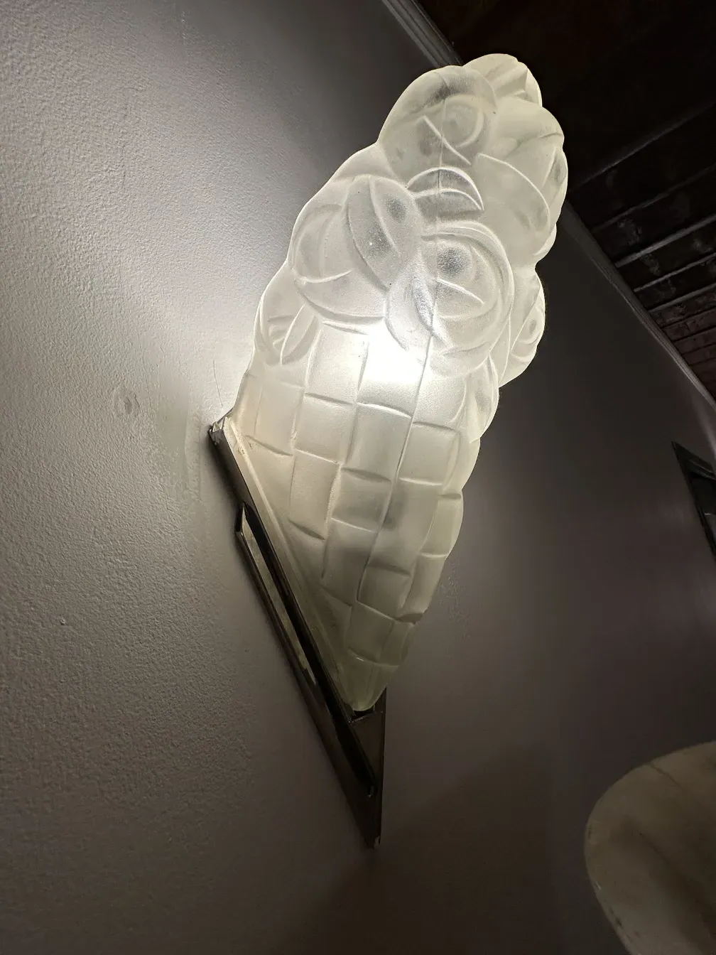 古董壁灯呈花形，墙面明亮，旁边是木质背景。