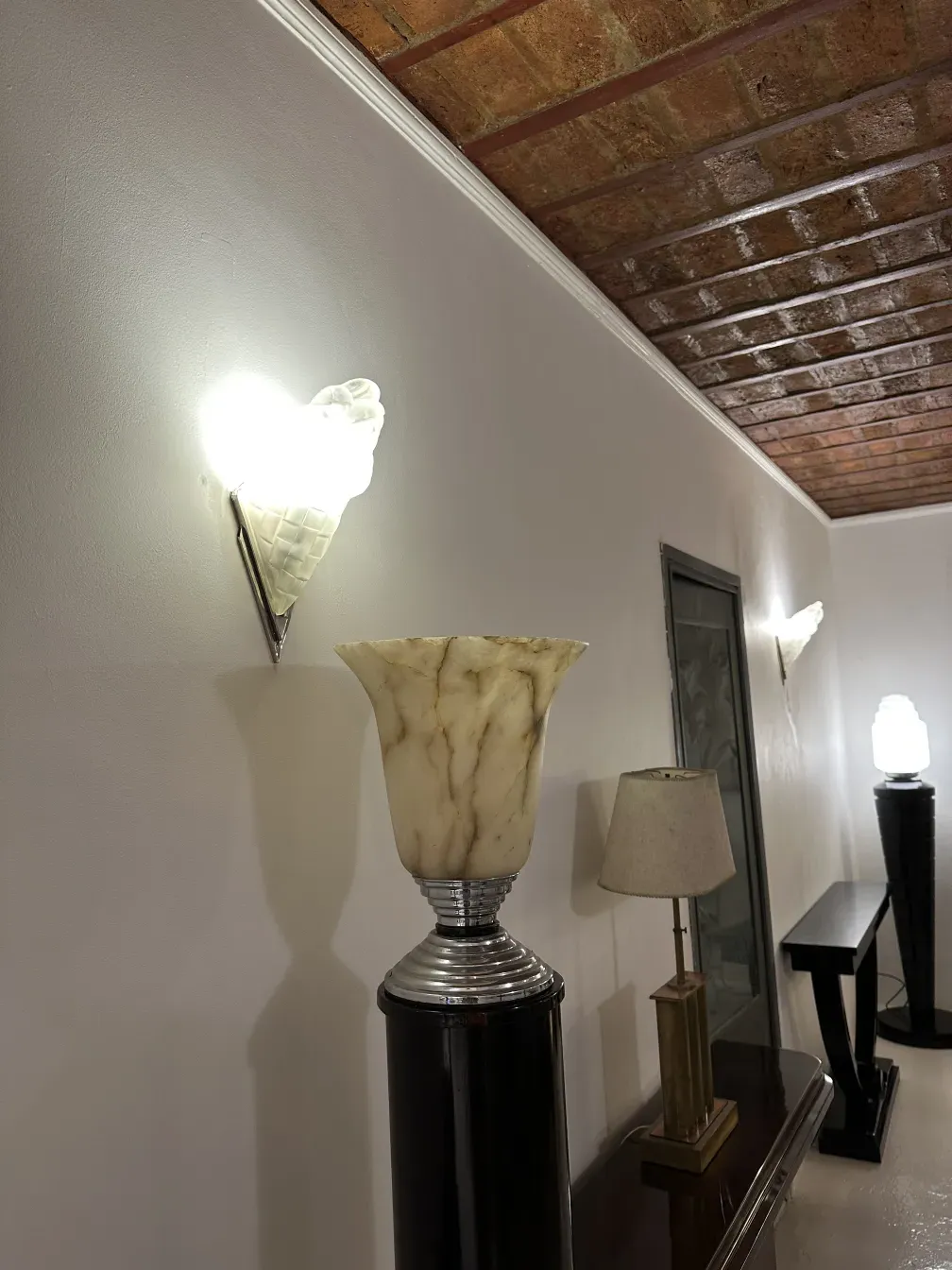 Una pareja de apliques de estilo antiguo en la pared, iluminando suavemente el ambiente con un diseño distintivo.