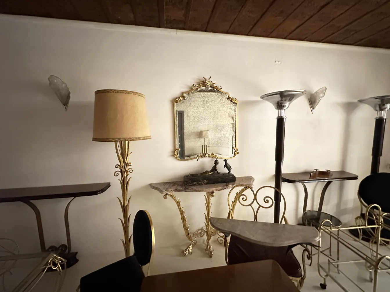 Paar antiker Wandleuchter in klassischer Umgebung mit Stehlampe und Spiegel.