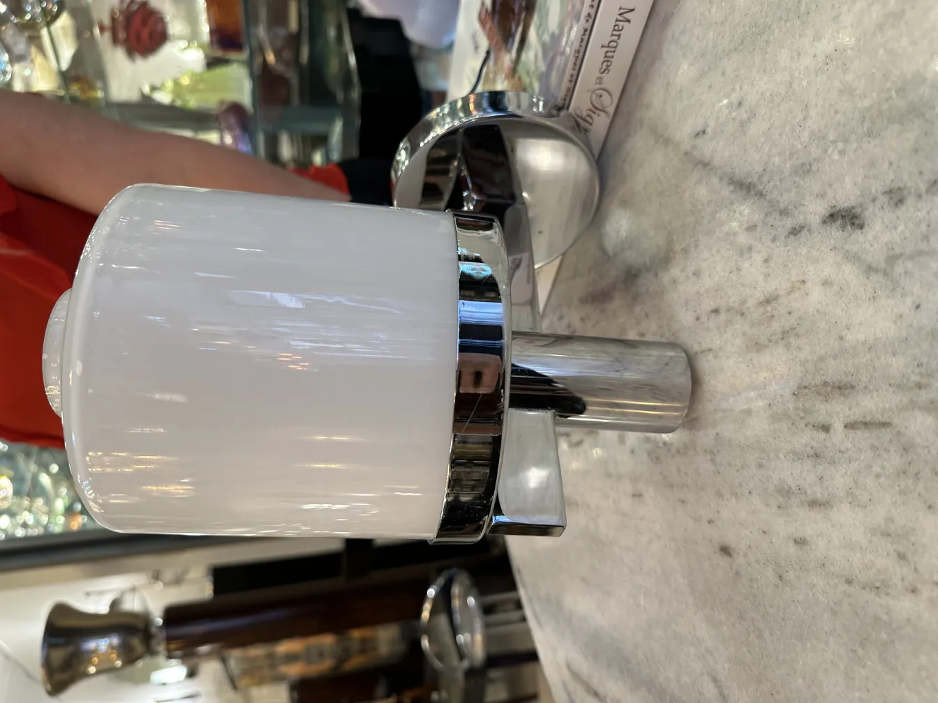 Pair of antique sconces with elegant shiny design. Seen on a marble surface.