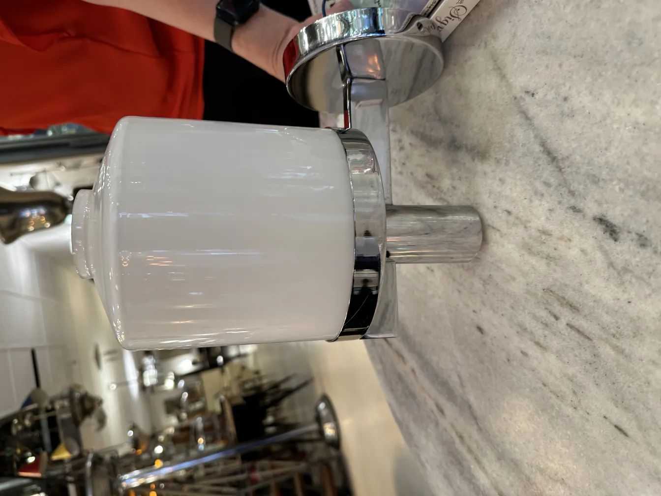 光沢のある金属製のベースと白い陶器のシェードを持つ古いウォールランプ、クラシックな環境に設置。