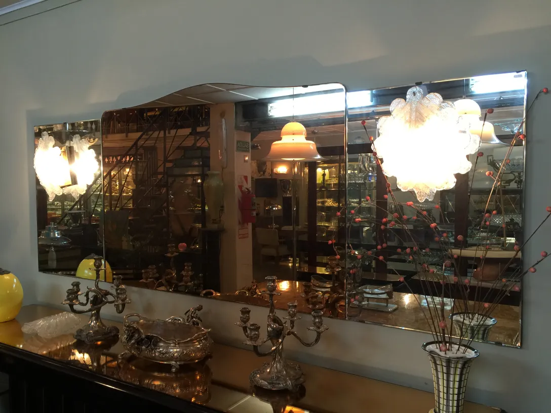 Paar antiker Wandleuchter, die eine Wand mit einem Spiegel beleuchten und dem Raum Eleganz verleihen.