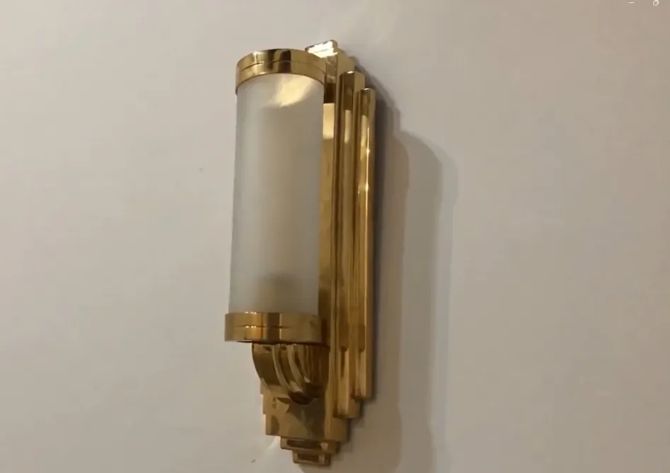Antique pair of elegant gold sconces with soft light.