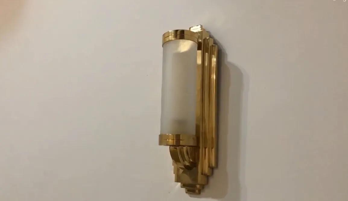 Elegant pair of gold sconces on the wall providing soft light.